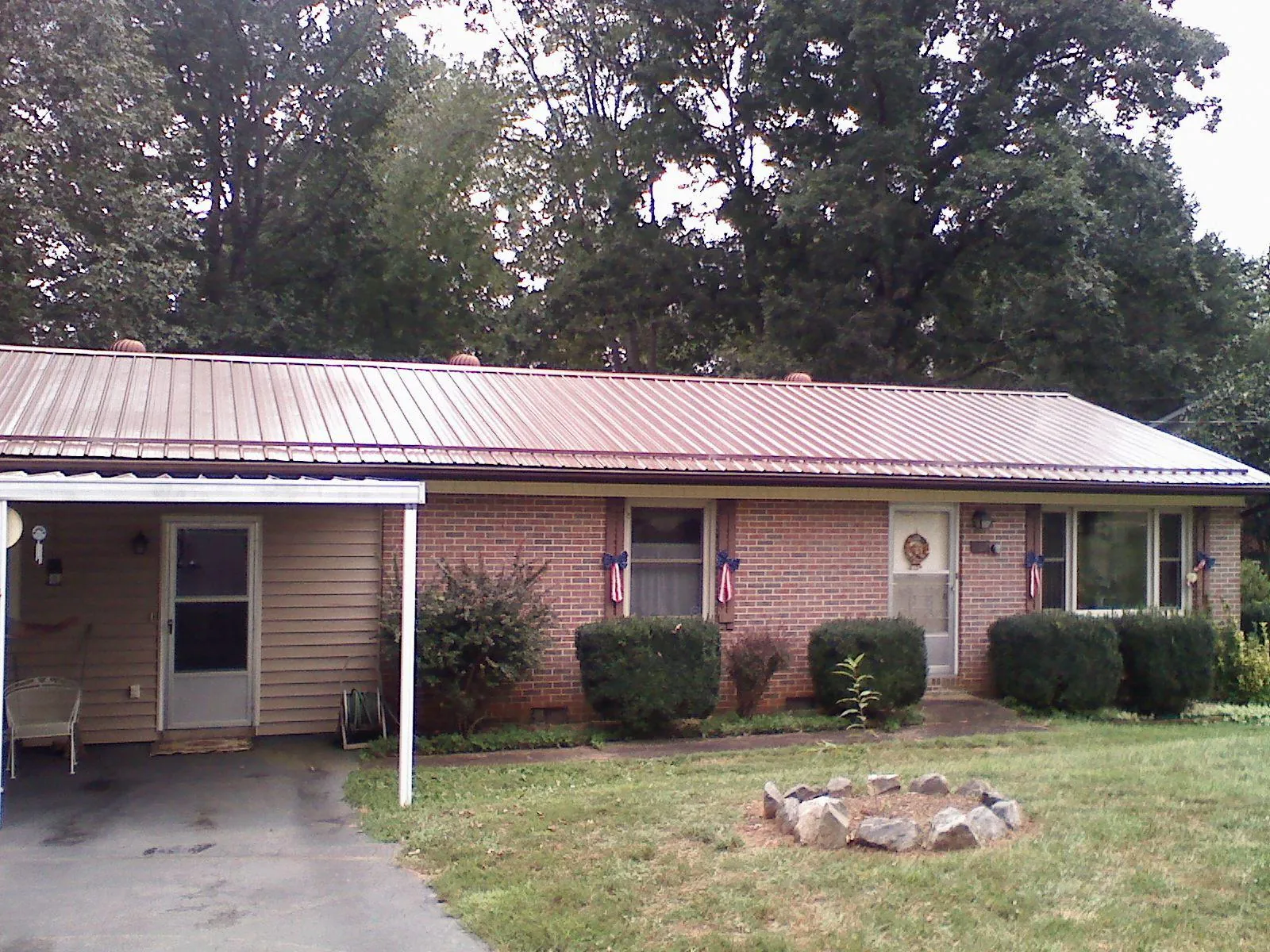 Bronze metal roof and carport on a brick ranch home — Roof Repair work by our crew in Fresh Meadows